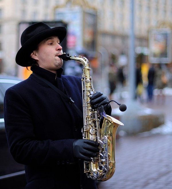 street musician, playing saxophone on a street. March 5, 2019. Kiev, Ukraine