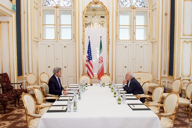 John Kerry at table with Iranian diplomat
