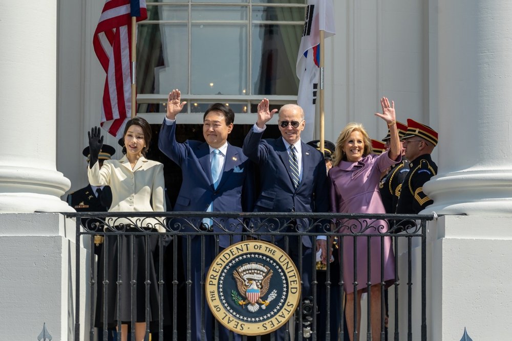 Presidents Yoon and Biden with their wives waving from the balcony at the White House