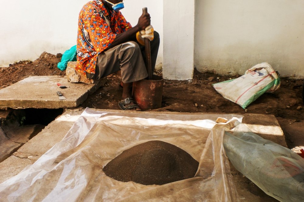 A Congolese man grinding coltan ore.
