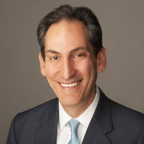 Jon Alterman is pictured in front of a brown background.