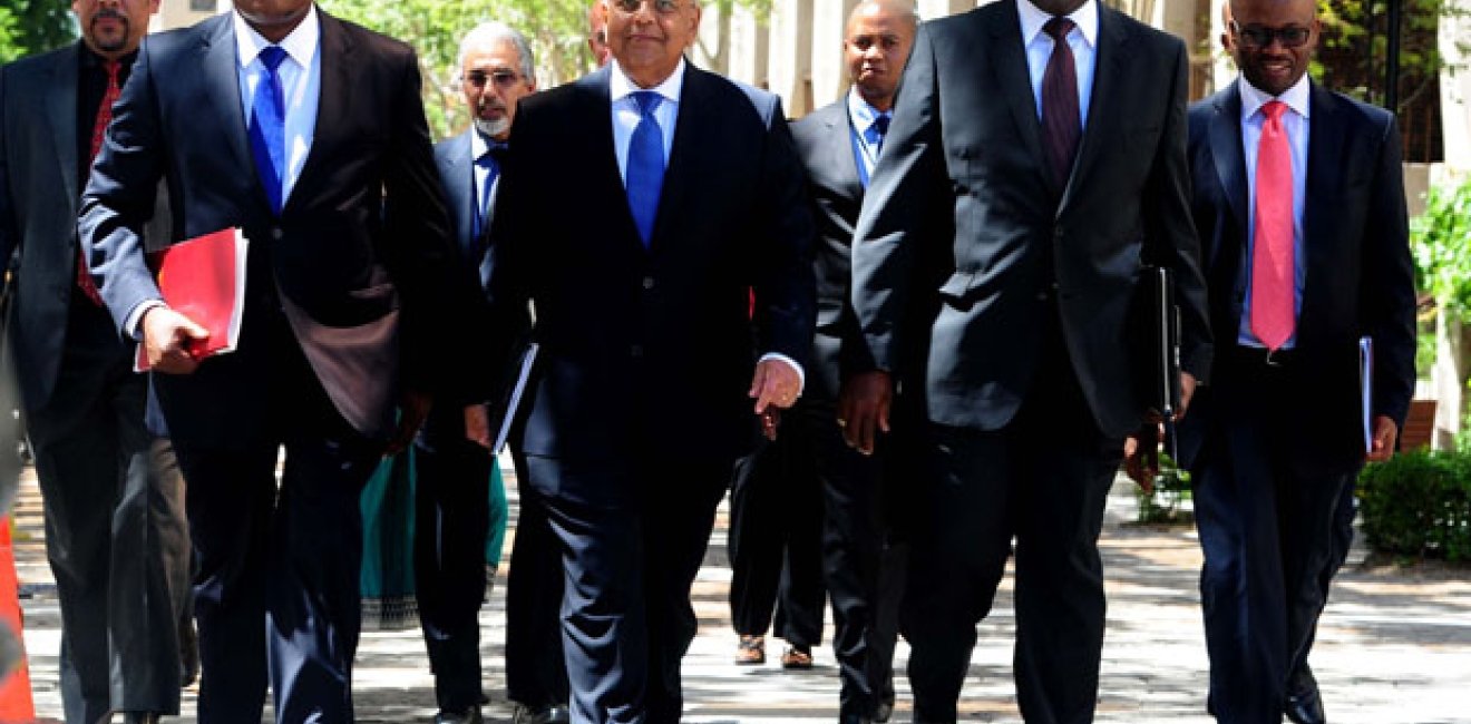 Once-and-current Finance Minister Pravin Gordhan, center, walks with now-former Finance Minister Nhlanhla Nene, left, ahead of a 2014 budget speech. Photo by Government of South Africa, Creative Commons via Flickr.