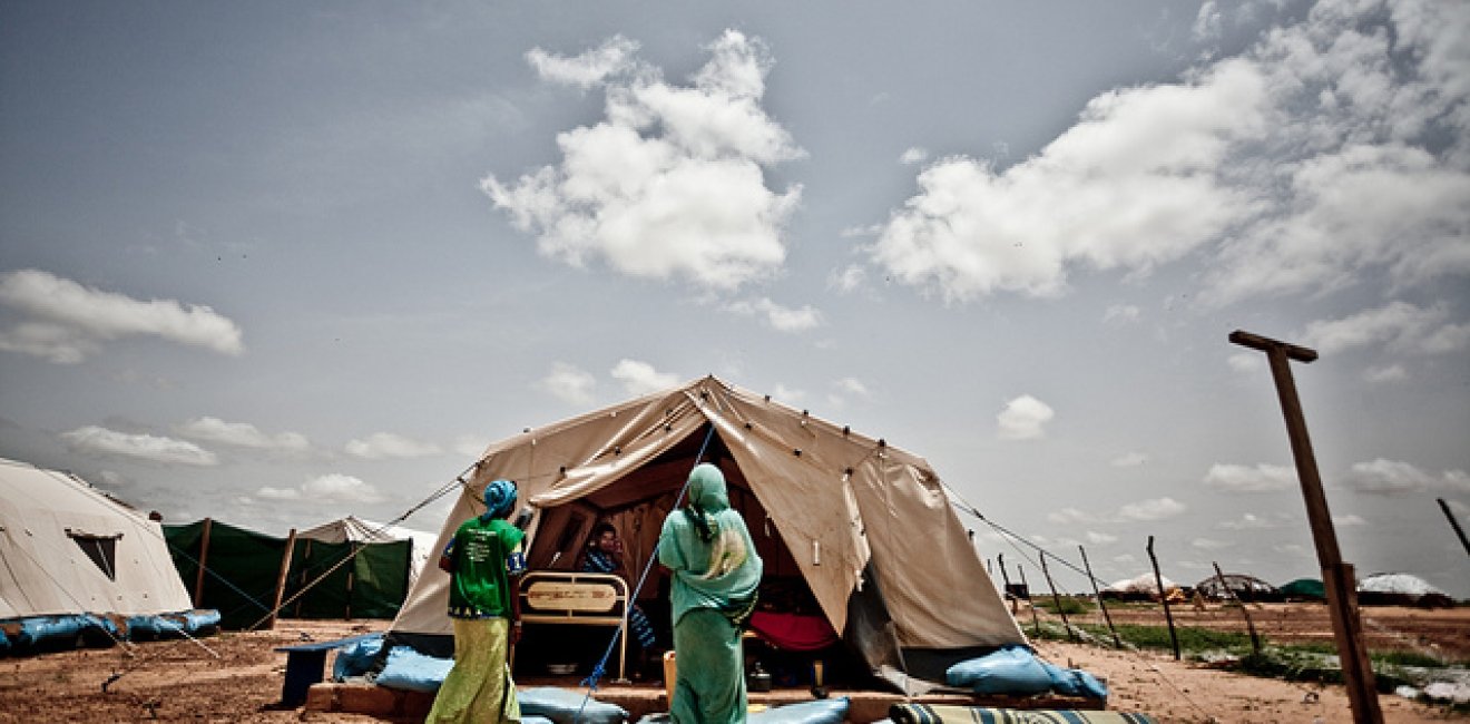 Two women enter a tent at the Mentao refugee camp in Burkina Faso in 2012, a camp formed from people leaving the conflict in Mali. Many African countries host far more refugees and migrants than Europe, and the fates of refugees and migrants are linked to