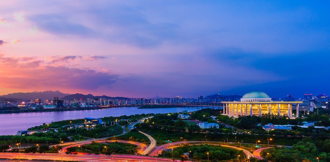 A wide shot of the city of Seoul with the National Assembly Building of South Korea in the background, shot at sunset.
