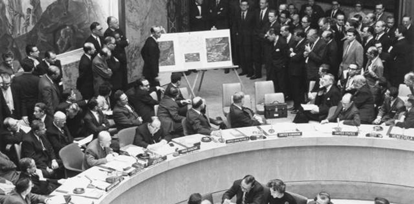 Adlai Stevenson shows missiles to UN Security Council with David Parker standing, October 1962