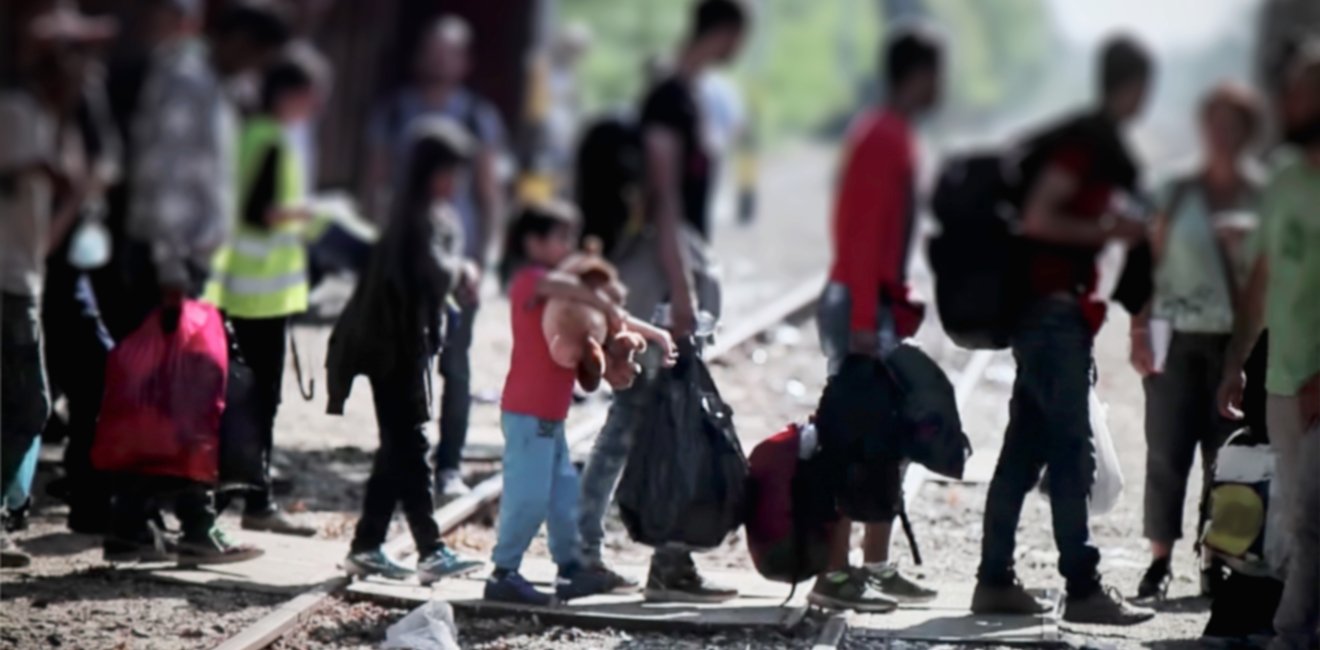 Refugees crossing train tracks in Europe