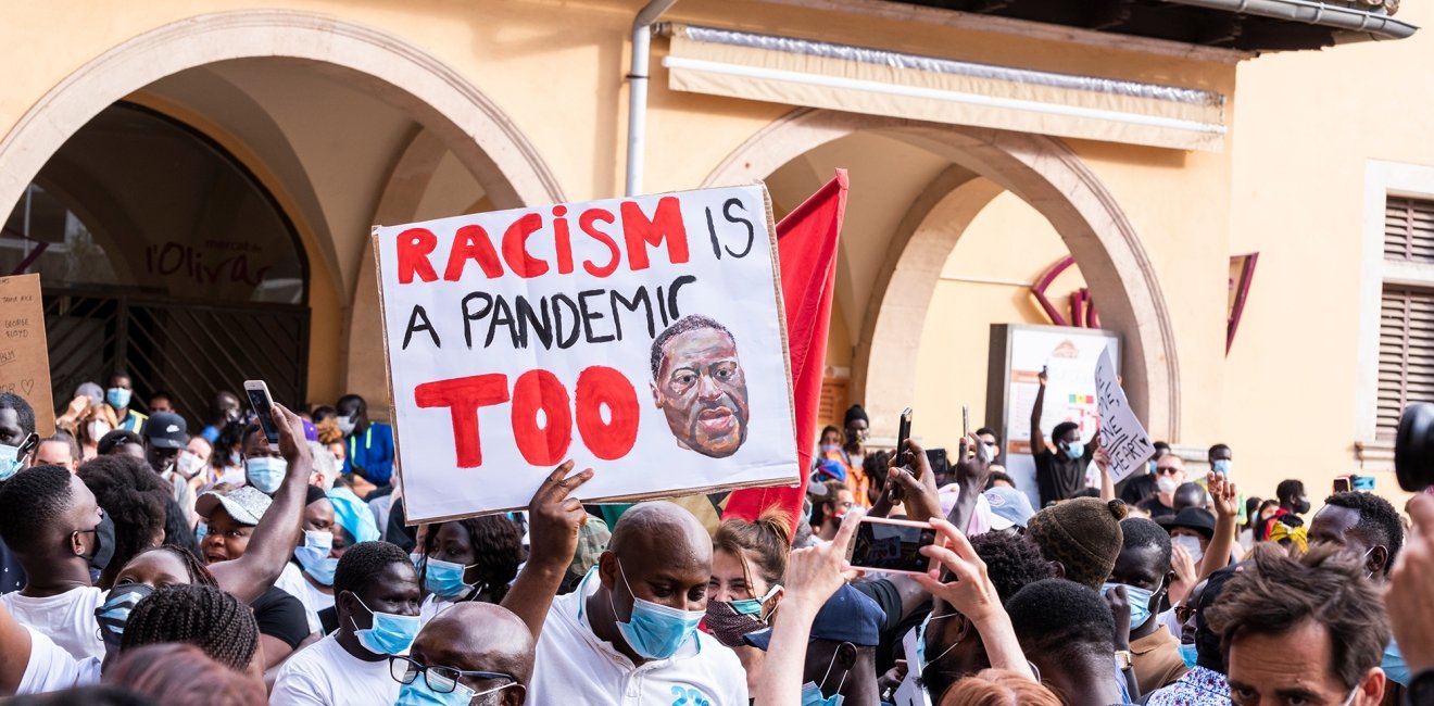 Palma de Mallorca, Spain - June 07 2020: Man surrounded by crowd holding a banner
