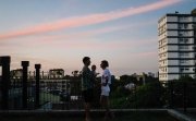Husband, wife, and baby on balcony overlooking city