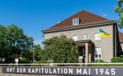 The Berlin-Karlshorst Museum with sign stating "Place of Surrender May 1945" and flying the flag of Ukraine