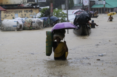 Women walking through flooded street, Bangladesh