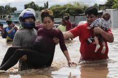 A pregnant woman is carried out of an area flooded by water brought by Hurricane Eta in Planeta, Honduras, Nov. 5, 2020.