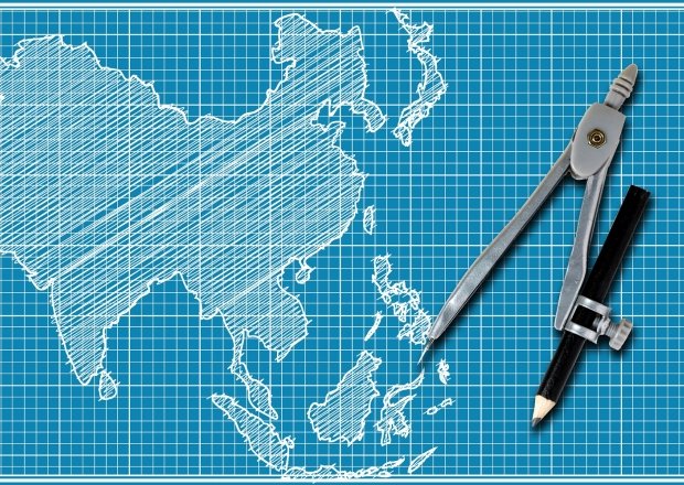 A blueprint style map of Asia with a drawing compass on top.