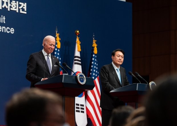 President Biden and President Yoon standing at two adjacent podiums with U.S. and ROK flags in the background.