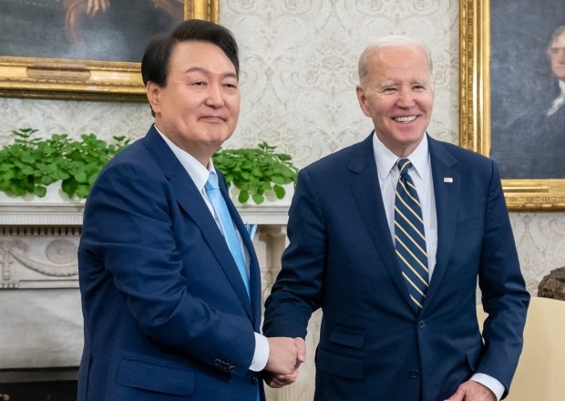 President Yoon shakes hands with President Biden in the Oval Office.
