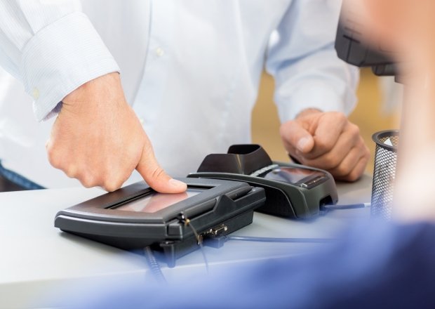 Man pushing thumb on fingerprint machine