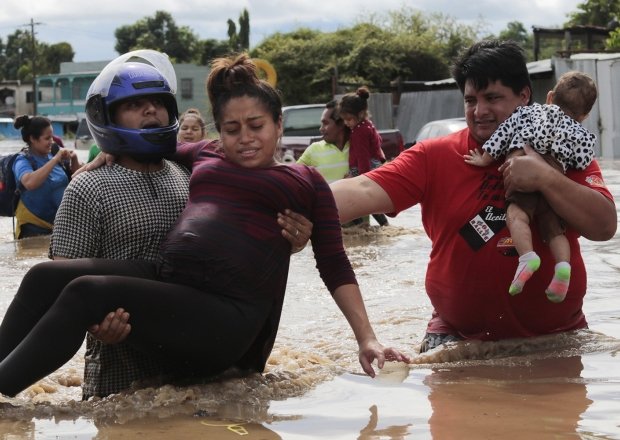 A pregnant woman is carried out of an area flooded by water brought by Hurricane Eta in Planeta, Honduras, Nov. 5, 2020.