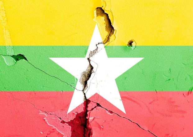 The Myanmar national flag painted on a cracked background