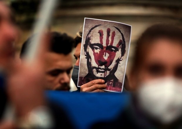 Putin's bloody face on a poster is shown during Ukrainian protesters with candles gather in Piazza del Campidoglio in Rome, against the war operations of Russia in Ukraine