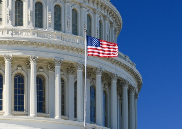 US Capitol Building dome detail with waving national flag - Washington DC, United States of America