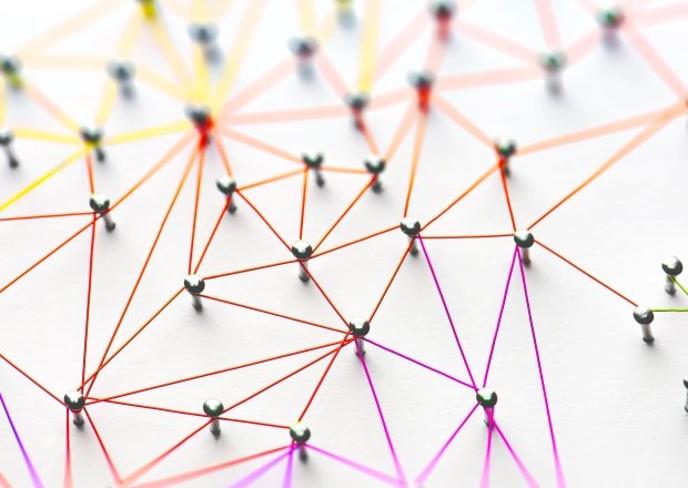 Linking entities. Networking, social media, SNS, internet communication abstract. Small network connected to a larger network. Web of red, orange and yellow wires on white background.