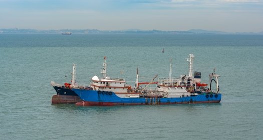 Chinese commercial fishing boats moored on the outer anchorage in the Strait of Singapore.