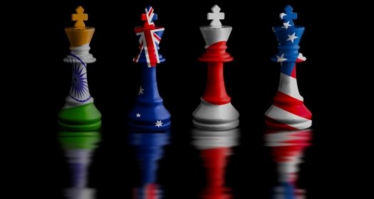 Four chess rooks with the flags of India, Australia, Japan, and the United States imprinted on them.