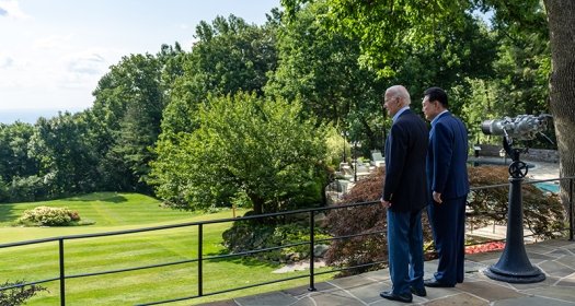 A photo of Presidents Biden and Yoon looking out on teh grounds in Aspen, Colorado