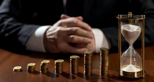 Pile of coins and an hourglass