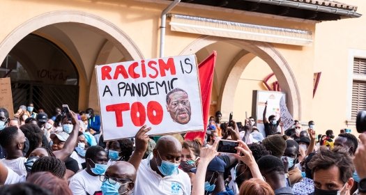 Palma de Mallorca, Spain - June 07 2020: Man surrounded by crowd holding a banner