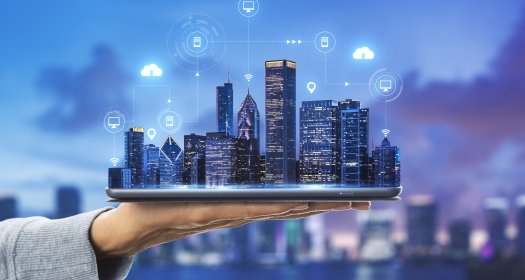 Smart city technologies concept with digital tablet and night megapolis city skyscrapers with digital cloud icons on human hand at blurry skyline background