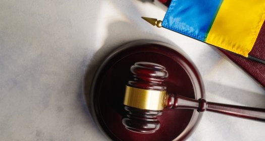 A gavel on a desk next to a Ukrainian flag