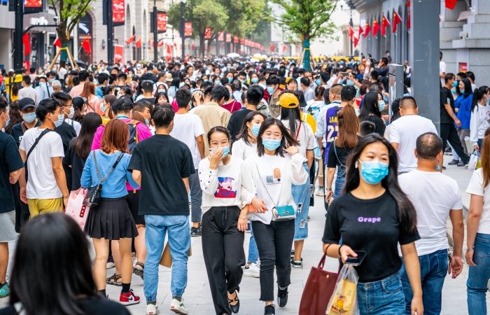 People walking along a street wearing masks in China 