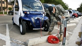 U.S. Army Spc. Dean Kalogris charges electric car at Fort Bliss, Texas.