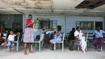 Children and women wait outside consultation rooms at the Port Reitz Hospital in Mombasa, Kenya, December 2019. Courtesy of Arete / Albert Gonzalez Farran for HP+; Saidu Kay Sesay (far right) vaccinating children at the Princess Christian maternity Hospital on March 10, 2015 in Freetown Sierra Leone. 