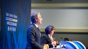Secretary Blinken stands at a podium giving a speech.