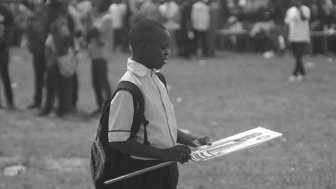 Young Nigerian boy holding a campaign sign.