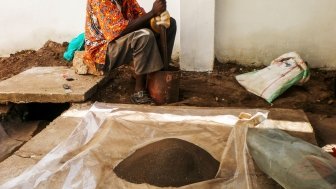 A Congolese man grinding coltan ore.