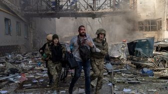 A person is helped by emergency personnel after an attack in a commercial area of Kharkiv