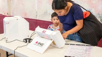 A woman casting her vote for State of Mexico's Governor using a new electronic ballot box system.
