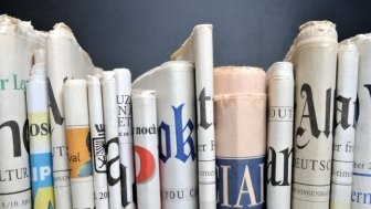 Newspapers lined up from different news outlets 