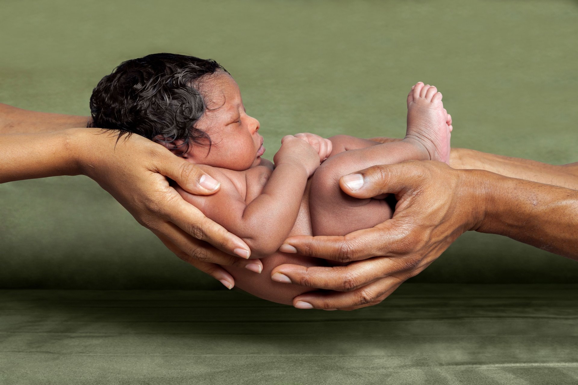 Infant held with two hands