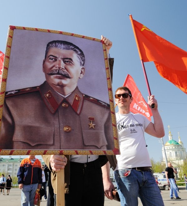 Orel, Russia - May 1, 2017: May demonstration. Young men with Stalin portrait and red Communist flags. Source: Alexey Borodin/Shutterstock