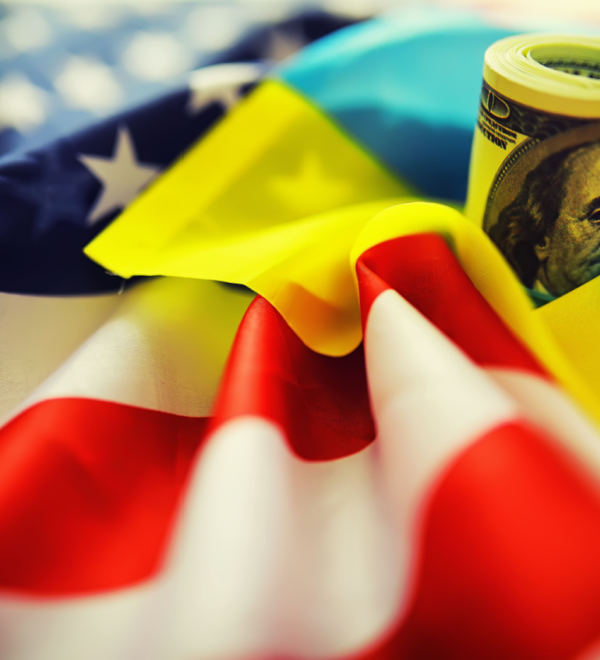 American and Ukrainian flags with a roll of American dollars