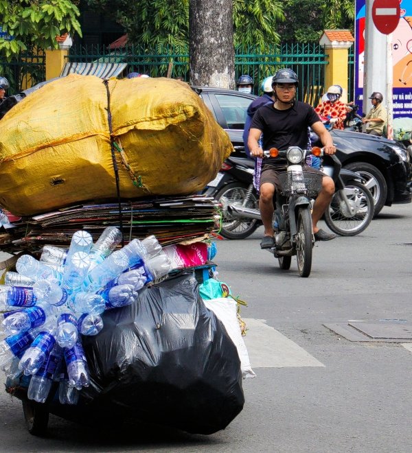 A person pushing a cart of plastic waste