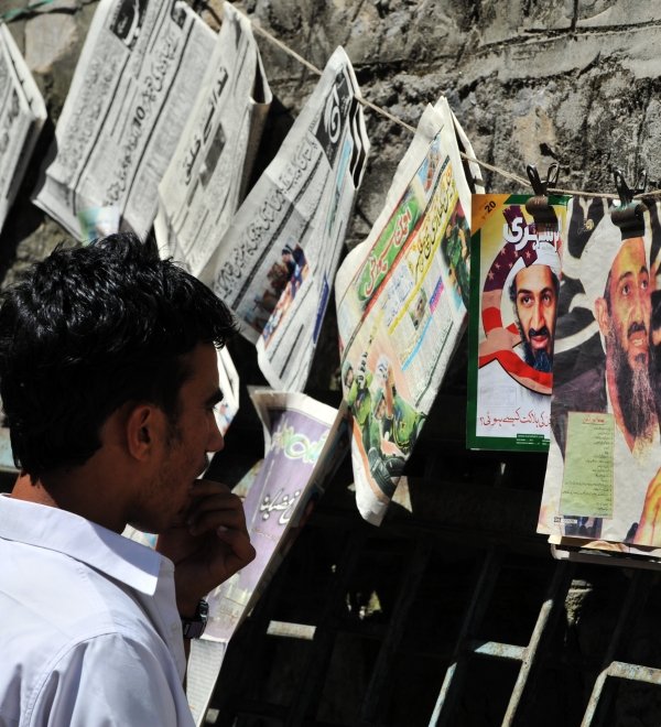 Man looking at Newspapers with Bin Laden's Photo