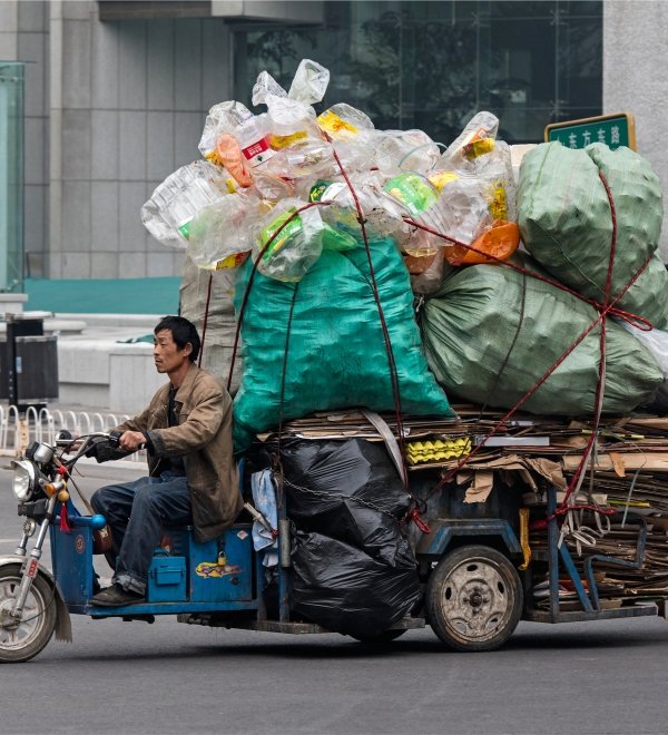 A man is seen on a freight bike loaded with recyclable materials.