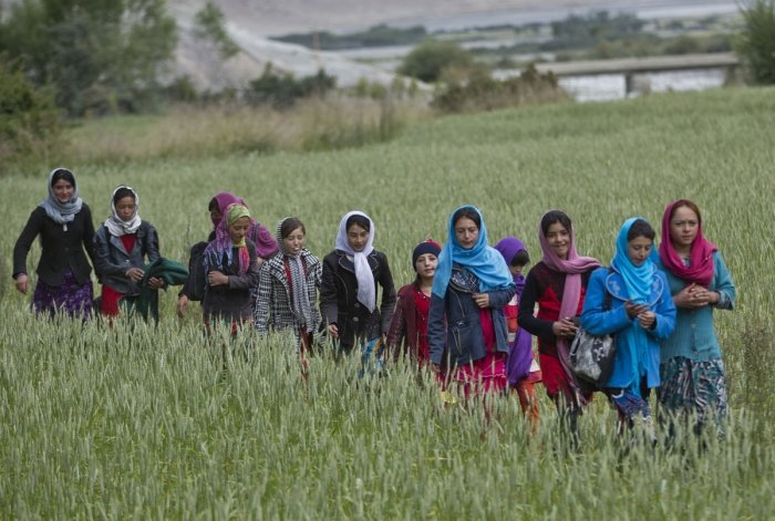 In this Thursday, Aug. 18, 2016 photo, young girls walk towards their school, in Wakhan, Badakhshan province, far northeastern Afghanistan.