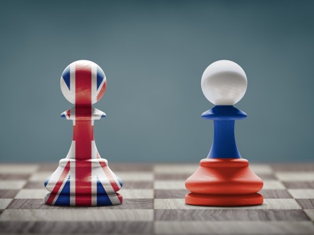 UK and Russia conflict. Country flags on chess pawns on a chess board. 3D illustration.
