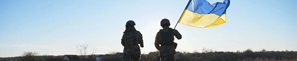 Soldiers waving a Ukrainian flag in a field