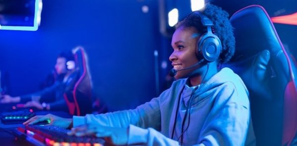 Portrait Streamer African young woman professional gamer playing online games computer, neon color.